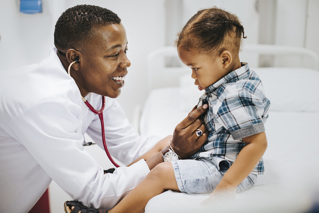 Pediatrician using a stethoscope to examine a child during a routine checkup